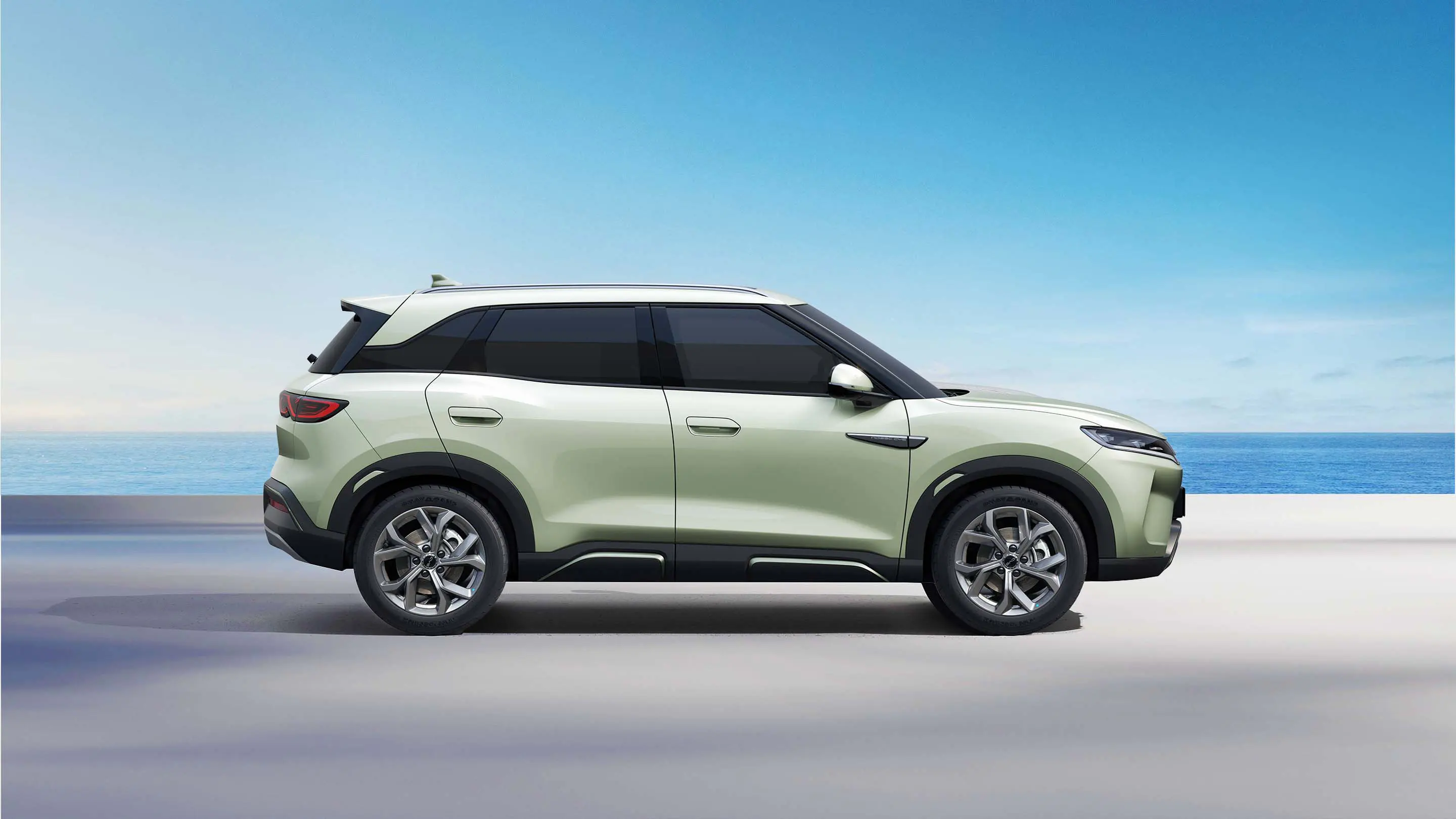 BYD Yuan Pro em vista lateral, na cor verde-claro, com fundo de céu azul e mar